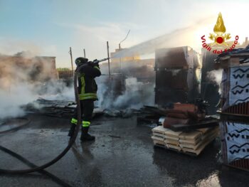 In fiamme materiale vario in piazzale interno di una attività commerciale, grossa colonna di fumo