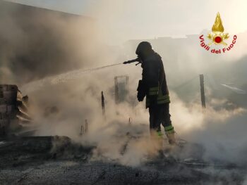 In fiamme materiale vario in piazzale interno di una attività commerciale, grossa colonna di fumo