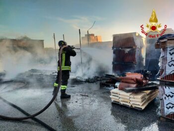 In fiamme materiale vario in piazzale interno di una attività commerciale, grossa colonna di fumo